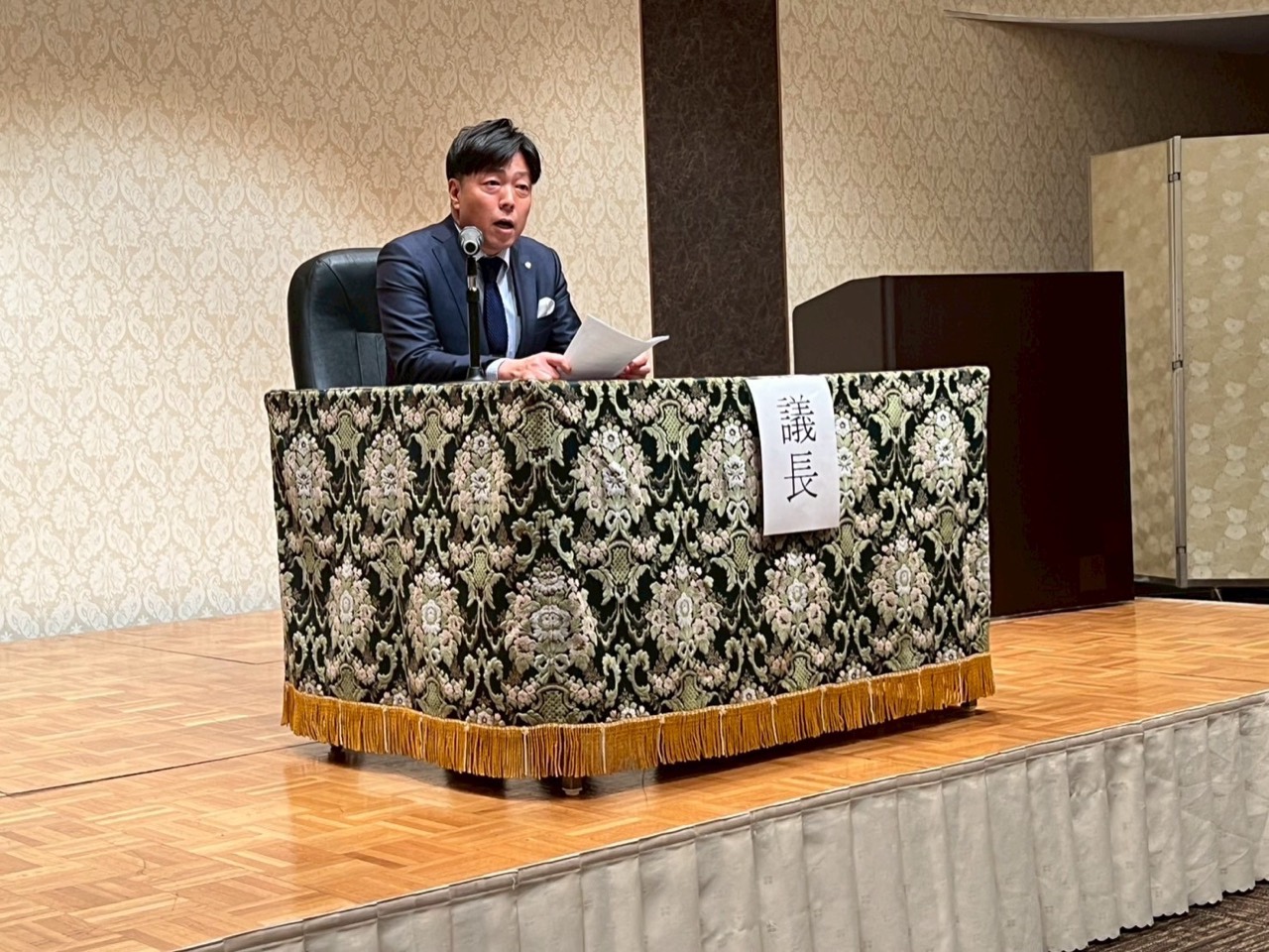 宮前区商店街連合会総会で議事を進行する馬場慎一郎